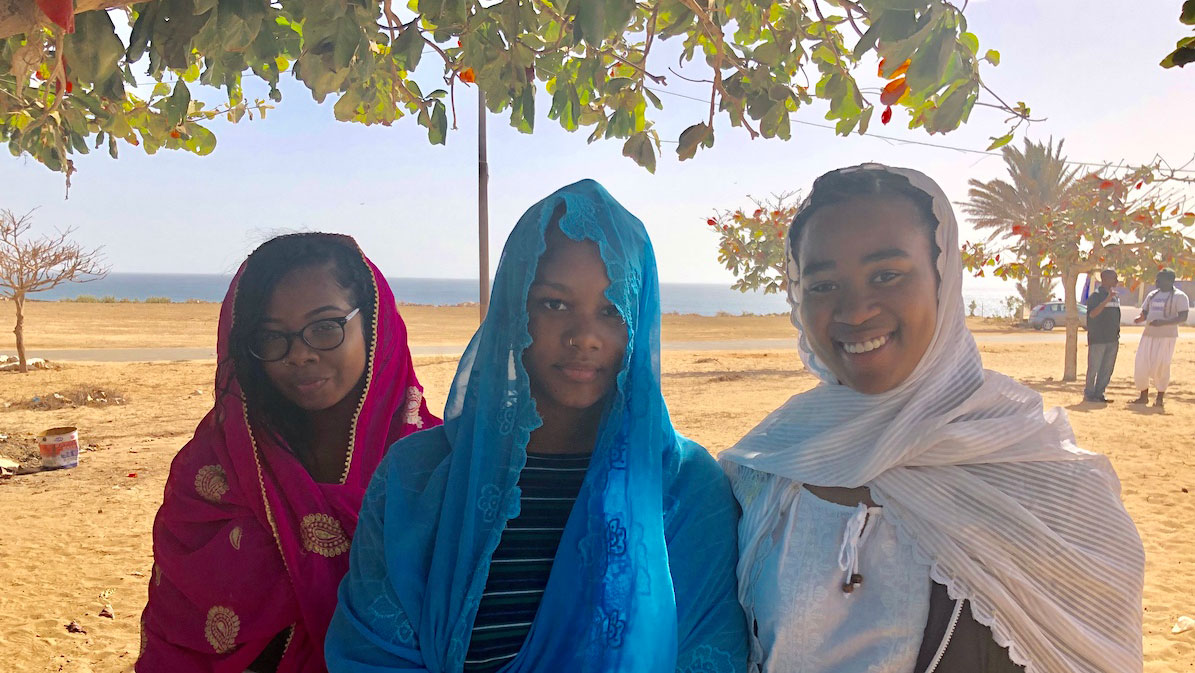Three student wearing shawls outside