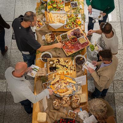 An overhead picture of people getting food from an all-you-care-to-eat table of gourmet food at LMU Wine Classic.