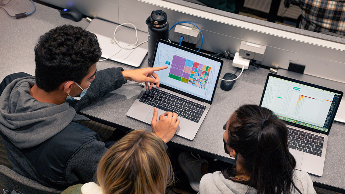 Several students working on a project displayed on a laptop screen