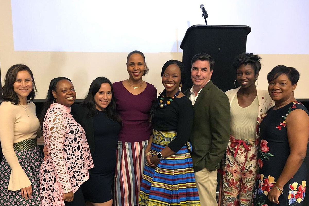 A group of SOE students after an event in front of a stage and podium