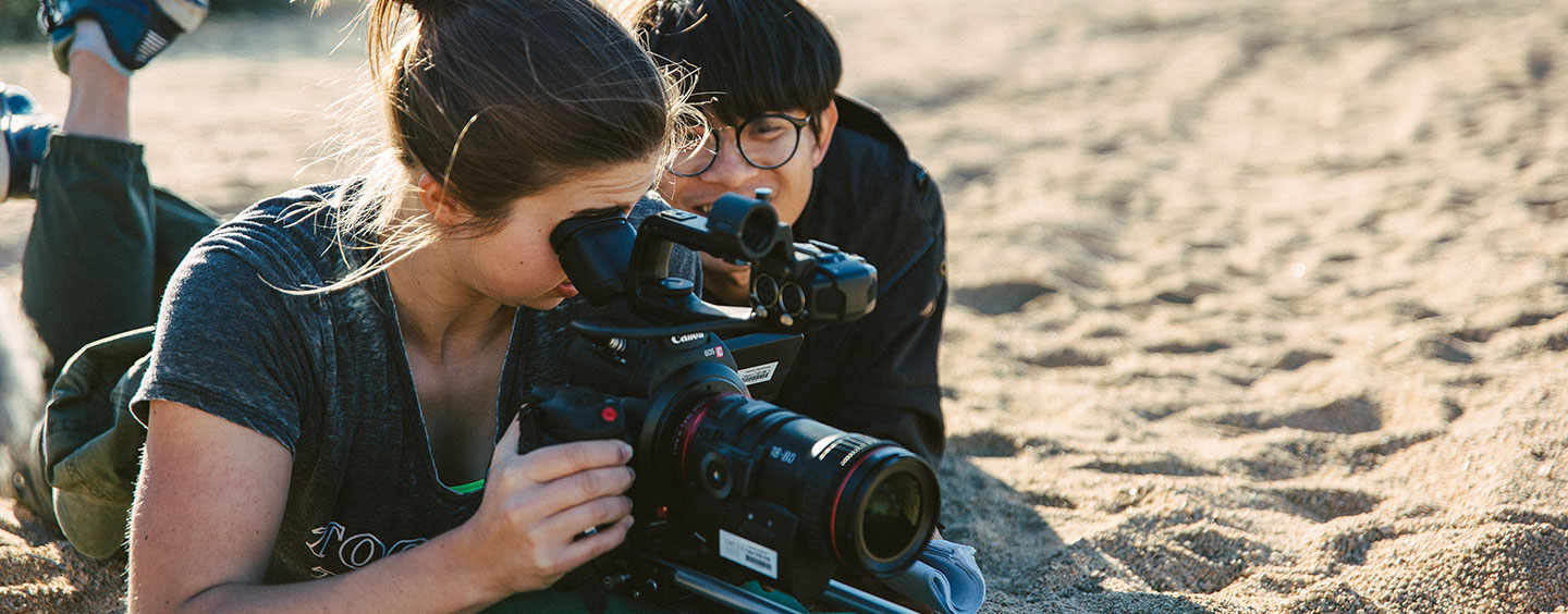 Two students shooting a ground-level video for a project