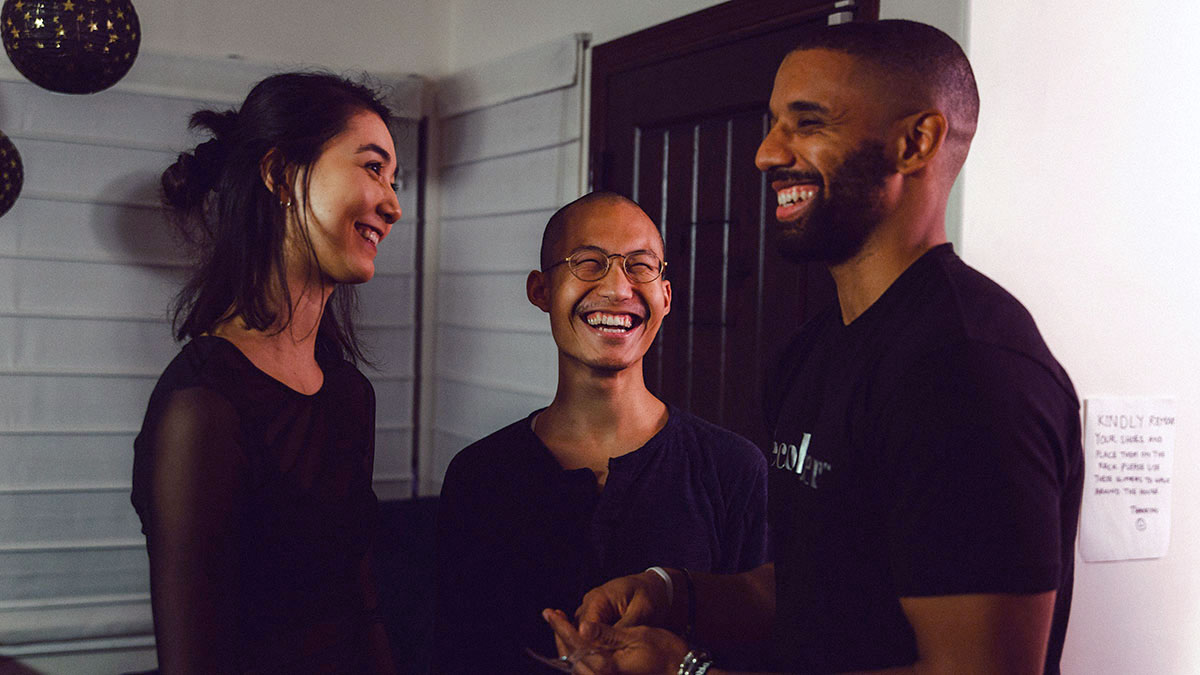 Three students having a laugh together between takes on set