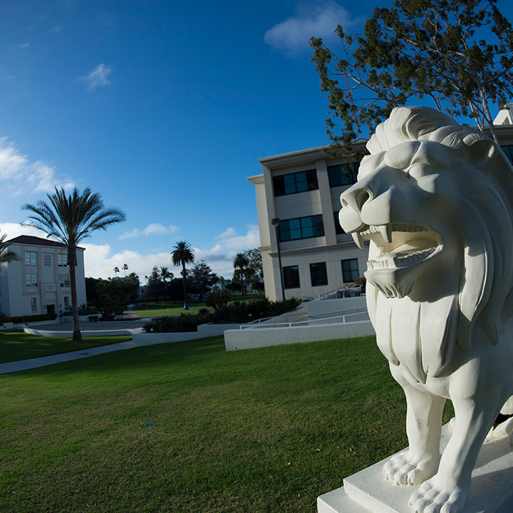 The Lion statue along Alumni Mall with Malone and St. Robert's in the background.
